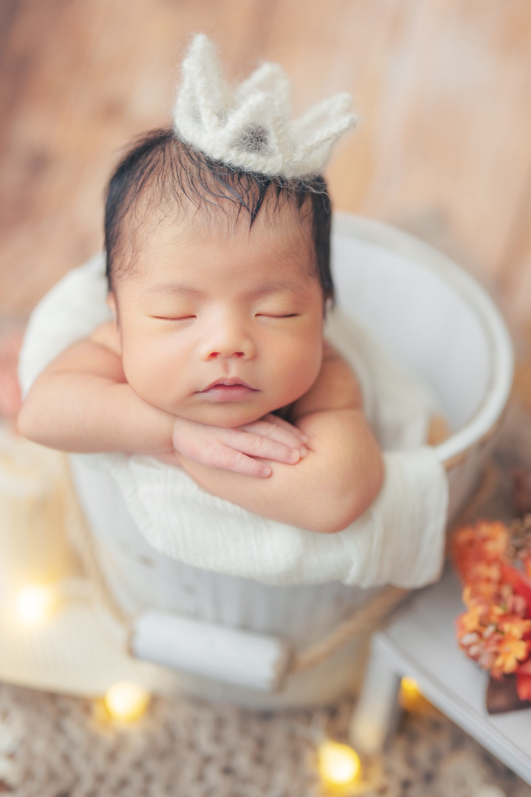 王冠をつけてバケツの中で眠る赤ちゃん